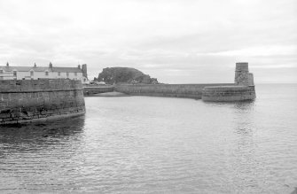 View from ENE showing entrance to harbour with light-tower on right and part of numbers 17-19 Harbour View in background