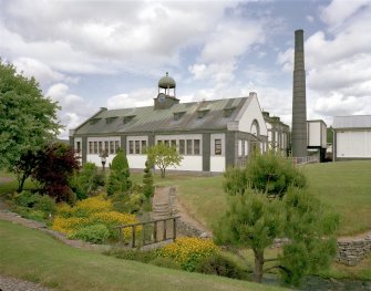 Exterior view from SW of former cooperage, also showing boilerhouse chimney, and examples of topiary typical of the distillery gardens
Digital image of C 34598 CN