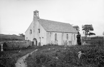 Lismore, St Moluag's Cathedral.
General view from North-East with man standing in graveyard.
