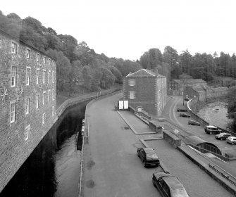 Elevated view from NW of NW end of School, with River Clyde and Dye Works and Engineers' Workshop buildings in the background, and the SW side of the Institute partially visible (left), with the lade in the foreground
