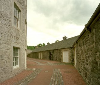 View from N of middle (kinked portion of) range of wool-preparation houses (converted to self-catering cottages), with Mill No.1 visible to left
