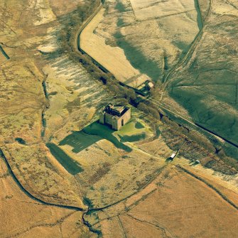 Hermitage Castle, oblique aerial view centred on the remains of a castle and earthwork castle, taken from the North West.