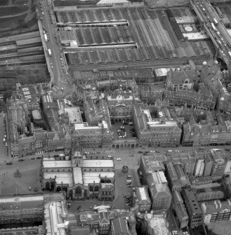 Oblique aerial view showing High Street between North Bridge and Lawnmarket, with St Giles' Cathedral in foreground, City Chambers in centre and Waverley Station at top.