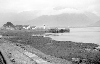 View from WNW showing lighthouse and wooden piled pier at entrance to Caledonian Canal