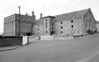 View from SE showing SSW and ESE fronts of E bay wing with castellated hoist block and central silo block