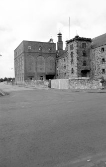 View from SE showing SSW and ESE fronts of E castellated hoist block and central silo block, with drying kiln vents visible