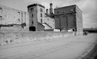 View from W showing SSW and WNW fronts of W bay wing castellated hoist block and silo block