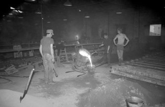 Interior
View showing men filling hand ladle