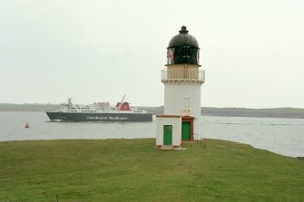 Elevated view of Arnish Point Lighthouse tower and store from WSW with Isle of Lewis ferry in background.
