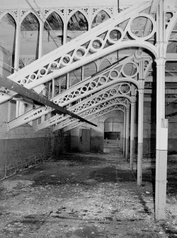 Interior.
View of cast-iron roof trusses and columns with gothic shaped wooden infills in central section of top floor of main building.
Digital image of A 38495
