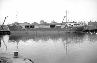 View from ENE showing coaster MV Fylhix moored on wharf opposite dry dock entrance