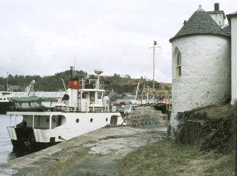 View from W showing W round tower of piermaster's house and ferry moored at pier