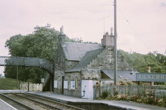 View from WSW showing NW and SW fronts of down platform building with footbridge