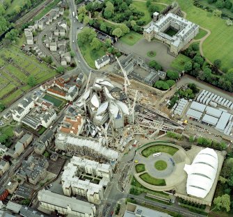 Oblique aerial view of Edinburgh centred on both 'Dynamic Earth' and the Scottish Parliament under construction, with the Canongate, Holyrood Palace and Holyrood Abbey adjacent, taken from the WSW.