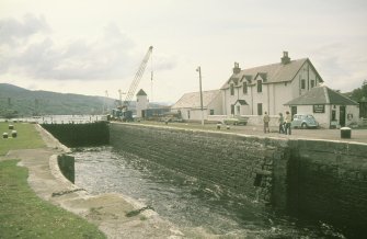 View from E showing entrance to canal with sea lock and lighthouse to the left