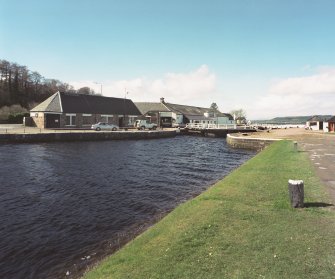 Inverness, Clachnaharry, Clachnaharry Road, Caledonian Canal, Clachnaharry Lock, Canal Workshops
View from the south-east showing Muirtown Basin in the foreground, the top lock gates of Clachnaharry Lock and the Canal Workshops beyond.  Also visible on the extreme right is the hand crane.
Digital image of D 64130 CN