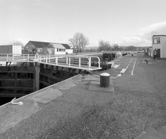 Inverness, Clachnaharry, Caledonian Canal, Clachnaharry Lock
View from the north-west showing Clachnaharry Lock with both gates closed, with a boat awaiting the opening of the gates.  The Canal Workshops are visible on the extreme right
Digital image of D 64136