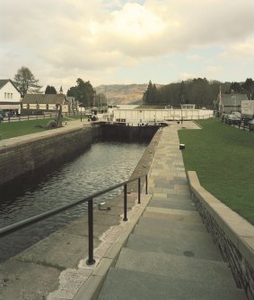 Fort Augustus, Swing Bridge over Caledonian Canal
An elevated distant view looking east-north-east down towards the swing bridge, with the first pair of lock gates visible immediately before the bridge.
Digital image of D 64040 CN
