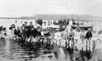 Historic photograph showing general view of school outing at beach.