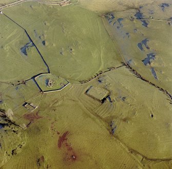 Oblique aerial view centred on the remains of the church, burial ground, homestead moat and building with rig adjacent, taken from the WSW.