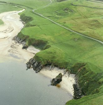 Oblique aerial view centred on the remains of the broch, taken from the ENE.
