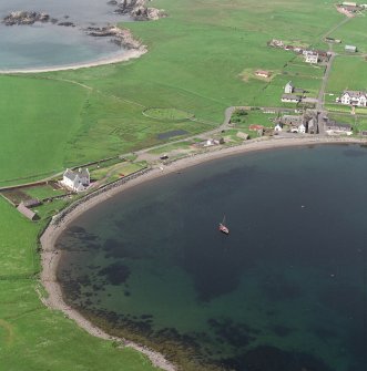 Oblique aerial view centred on the burial ground and village of Hillswick, taken from the SE