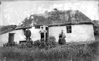 Three people in front of thatched cottage in Branault, Highlands, photographed from south west.