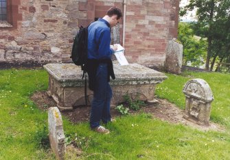 Gareth Wells recording a gravestone.