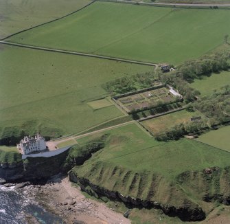 Oblique aerial view of Dunbeath Castle and walled gardens from NE.
