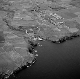 Oblique aerial view of Lybster, taken from the SW, showing village and harbour.