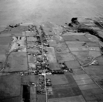 Oblique aerial view of Lybster, taken from the SW, showing village and harbour.