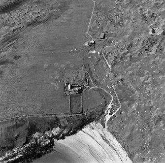 Oblique aerial view of Crossapol centred on a house and the remains of a farmstead and burial ground, taken from the SE.