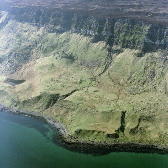 Oblique aerial view centred on the remains of the farmstead, shieling-huts and rig with fort adjacent, taken from the ENE.