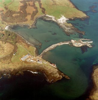 Oblique aerial view centred on the construction of the new pier, with harbour, pier and fish traps adjacent, taken from the S.