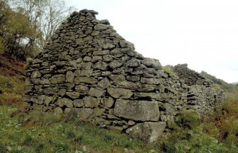 SW gable of building (BL00 733) within township. There are cupmarks on the two lower quoins in the S corner (in foreground).