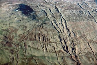 Oblique aerial view of head-dykes and braided trackways above Ben Lawers and Easter Croftintygan farms, Lochtayside. Taken from SE.