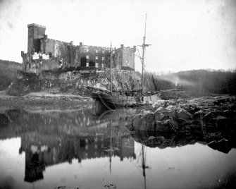 General view of Dunvegan Castle from west with sailing ship at anchor.
