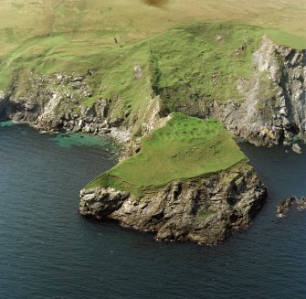 Oblique aerial view centred on the remains of the monastic settlement, taken from the ENE.