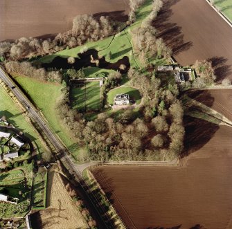 Scanned image of oblique aerial view centred on the country house, farmhouse and stables taken from the SE.