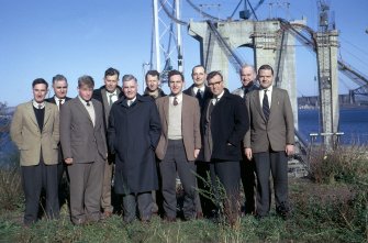 The A.C.D. [Arrol, Cleveland, Dorman] Bridge Co.'s Staff Engineers on site. (Left to right, front row) R J  Webb, Asst. Eng.; C D Strachan, Asst. Eng.; Sir Hubert Shirley-Smith, Site Agent; J H Hyatt, Section Engineer.; C H Fairweather, Section Eng.; H A G Smith, Asst. Eng.; (back row, left to right) H Hill, Staff Eng. Roebling  Corp.; J Kinsella, Senior Eng.; H S G Knox, Section Eng.; J C Kaye, Section Eng. and R B Wood, Deputy Site Agent.
Copy of original 35mm colour transparency
Survey of Private Collection