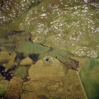 Oblique aerial view centred on the remains of the broch with the remains of the structure adjacent, taken from the E.