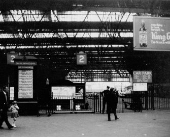 Scanned image of view of platform ends, concourse and departure board.