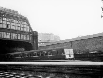 Scanned image of view from platform looking east to Lothian Road showing part of roof, train and Castle in background