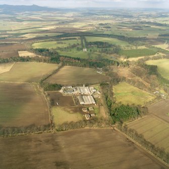 Oblique aerial view of the tower-house and its policies with Bennachie in the background, taken from the S.