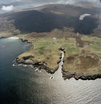 General oblique aerial view centred on the crofting townships, cave and the remains of the radar station, taken from the NNE.