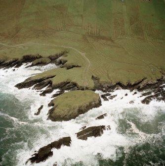 Oblique aerial view centred on the remains of the settlement with the remains of lazy beds adjacent, taken from the NNE.