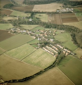 Oblique aerial view centred village with country house and walled garden adjacent, taken from the E.