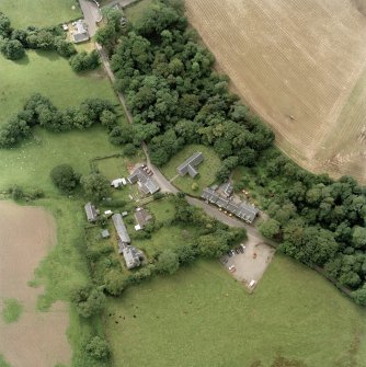 Oblique aerial view centred on the church, churchyard and hotel, taken from the NE.