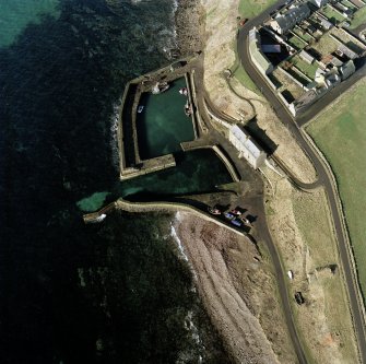 Oblique aerial view centred on Keiss harbour, with the warehouse, pillbox and icehouse adjacent, taken from the W.