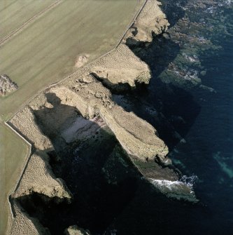 Oblique aerial view centred on the remains of Ness broch, taken from the E.